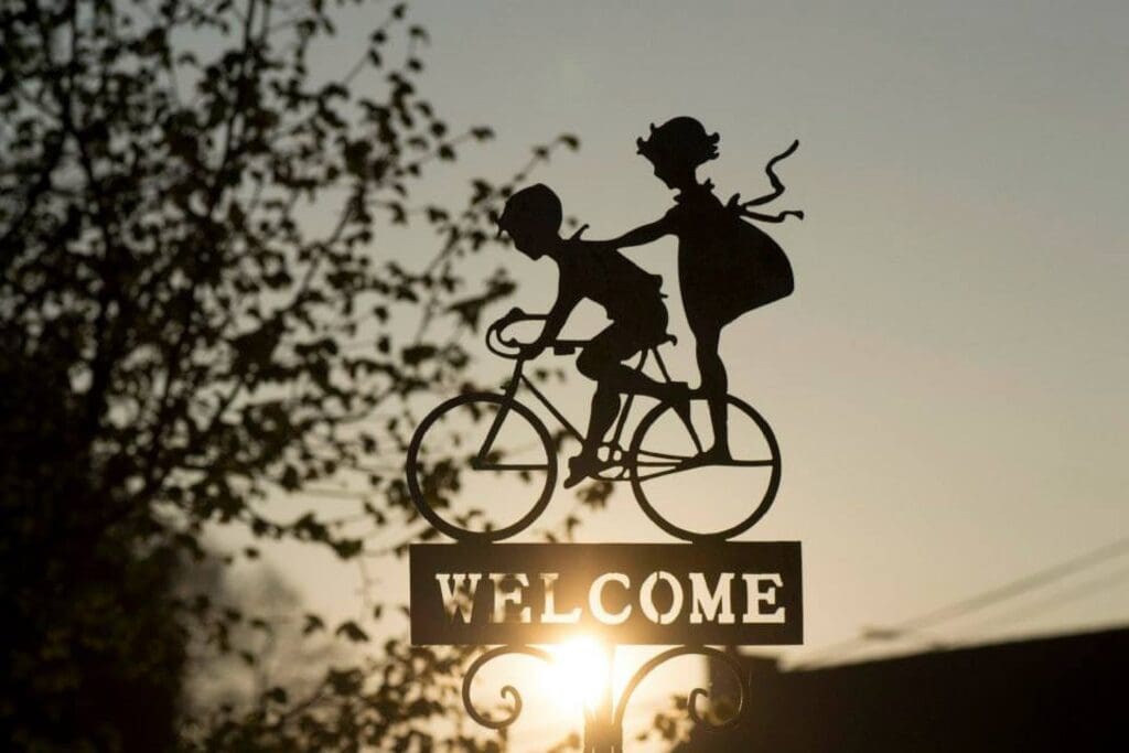 Welcome sign with kids riding a bike
